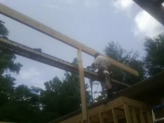 Carpenter setting a ridge beam over a new addition frame — Ice Dam Removal by Roofing Brothers in Panama